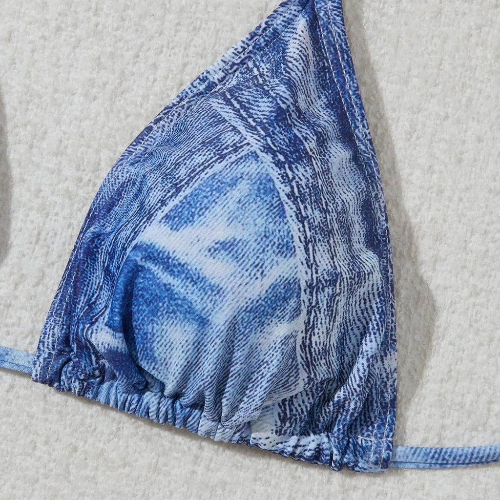 Denim blue printed women's bikini set with strap design on a white background.
