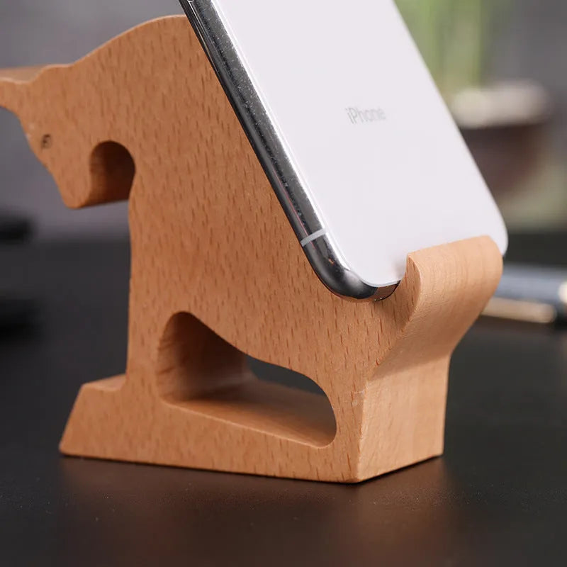 Beech wood and resin lazy bracket mobile phone holder with decorative animal design on a desk.