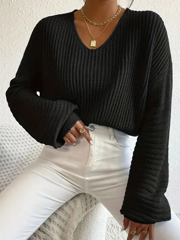 A woman's loose-fitting long sleeve pullover top in a solid colour.