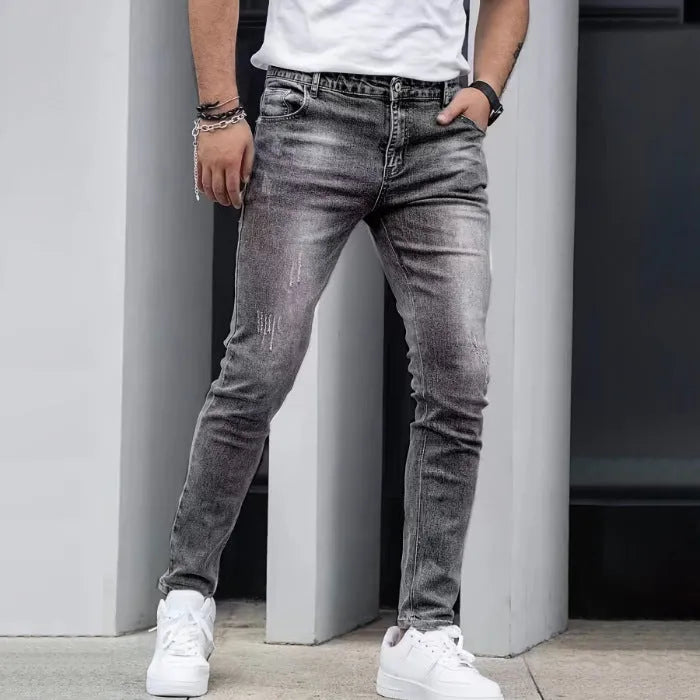 Men's straight-leg stretch jeans in black, dark blue, or grey, showing skinny leg opening and mid-waist fit.