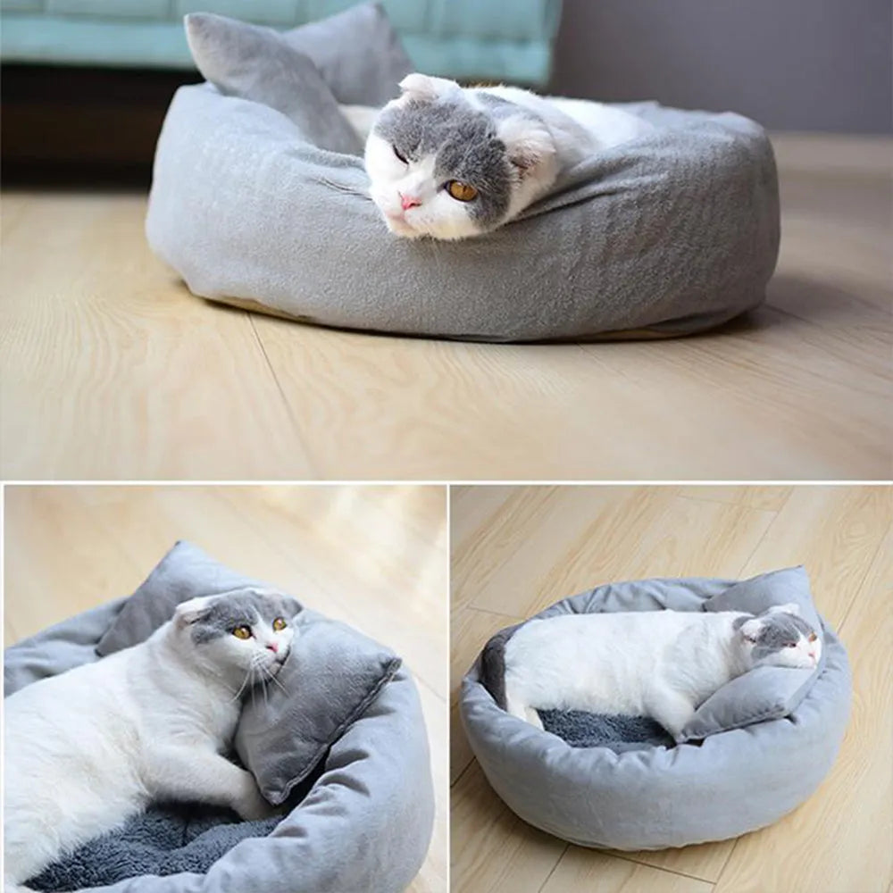 Grey round pet bed with raised rim and pillow for small dogs or cats on a wooden floor.