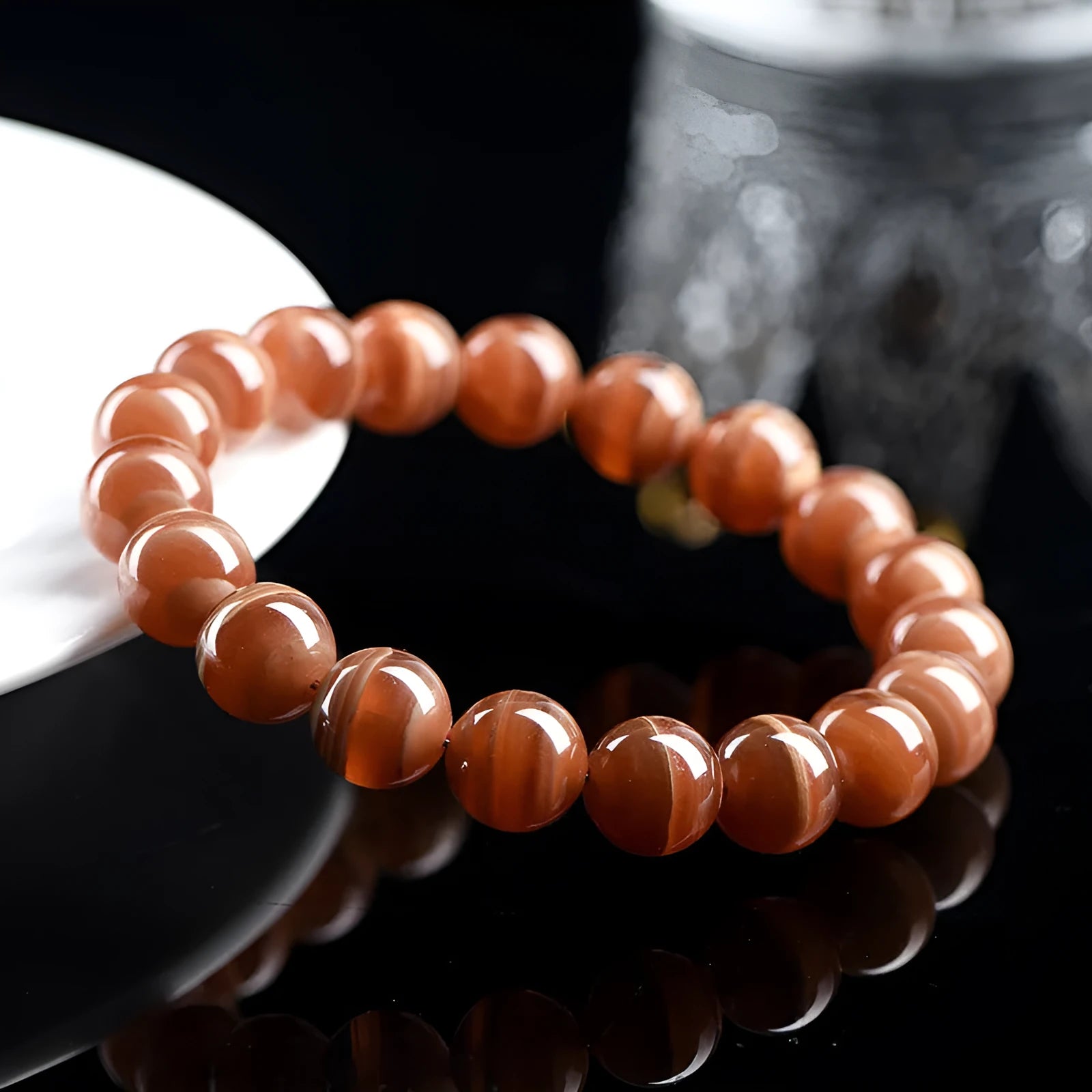 Natural old mine rhodochrosite bracelet with geometric beads and Ruyi symbols on a wrist.