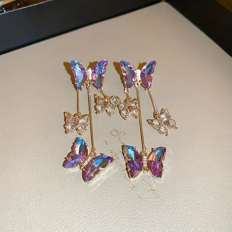 A pair of blue purple butterfly coloured alloy earrings with crystal flowers and a drop tassel.