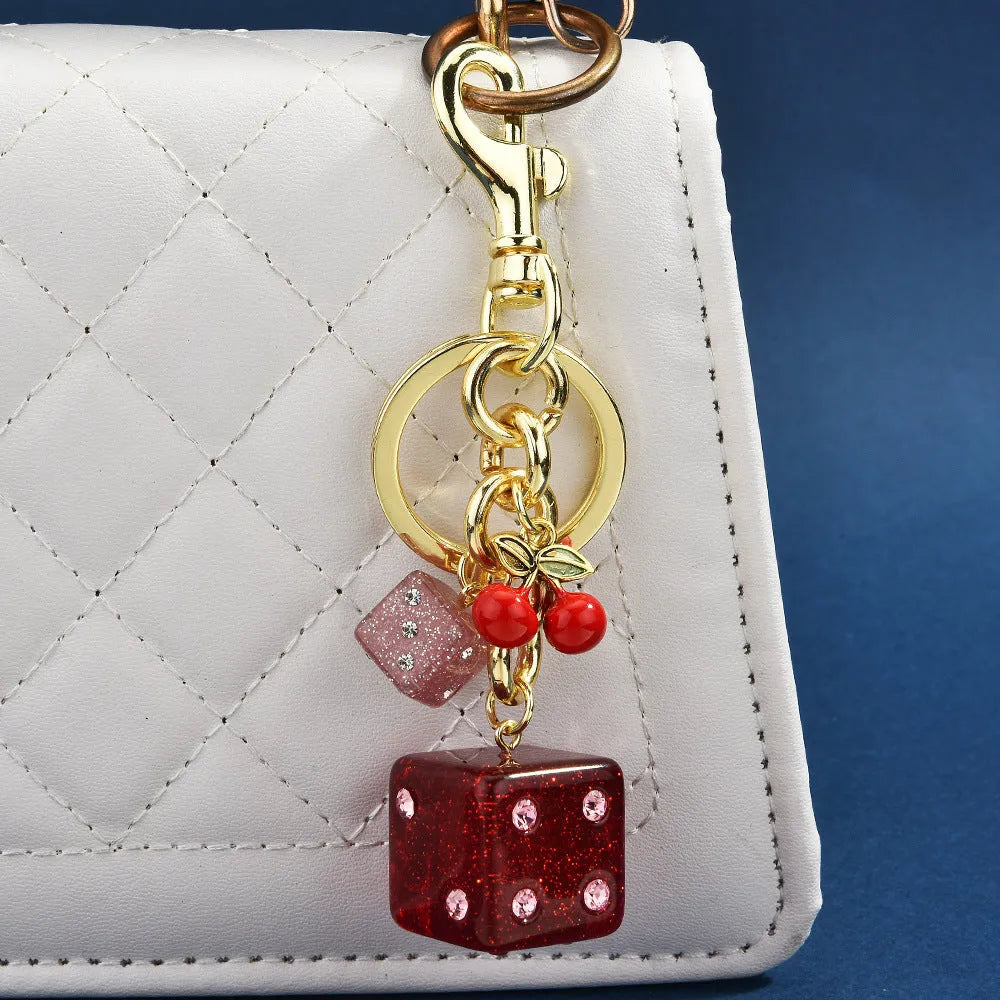 Square metal keychain pendant with a vintage cherry two-tone dice pattern and electroplated finish.