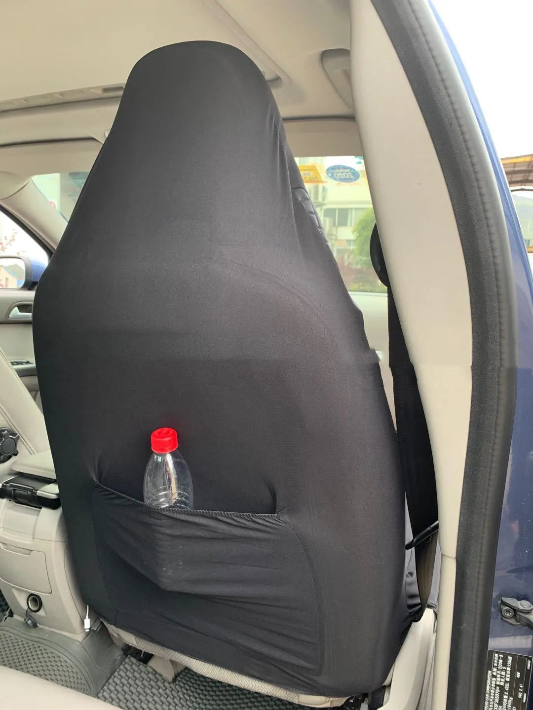 Black quilted universal car seat cover made of PU leather and polyester composite with plastic hooks.