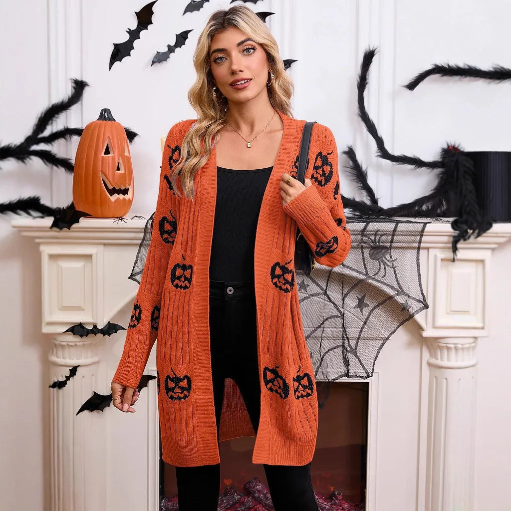 Women's black Halloween cardigan with orange pumpkin head jacquard pattern, shown as a medium-length knitted coat.