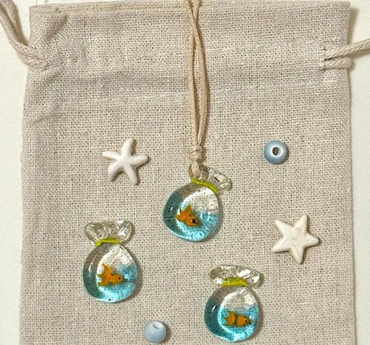 Women's pendant necklace with coloured glaze joker charm on a cotton and linen clavicle chain.