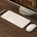 Ultra-thin white wireless keyboard and mouse set with USB receiver on a desk.