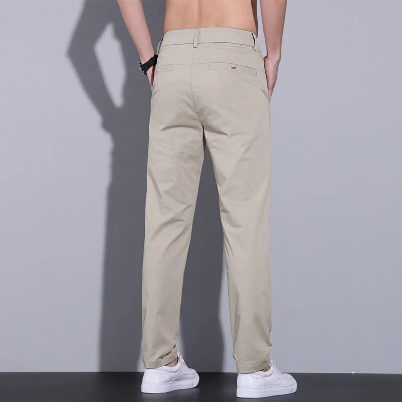 Men's straight slim fit cotton casual trousers in light khaki colour, laid flat.