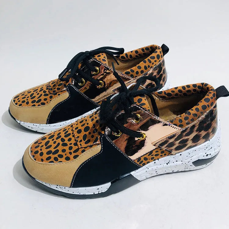 Women's black suede casual sneakers with a wedge heel and round toe on a plain background.