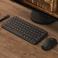 Ultra-thin white wireless keyboard and mouse set with USB receiver on a desk.