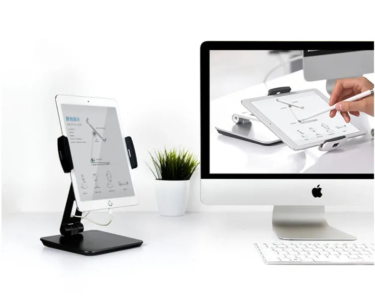Silver foldable aluminium phone tablet stand with 360-degree rotating bracket on a desktop.