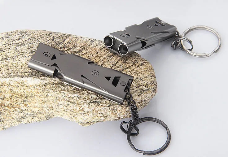 Compact keychain whistle in black and silver with keychain attachment for portable emergency signalling