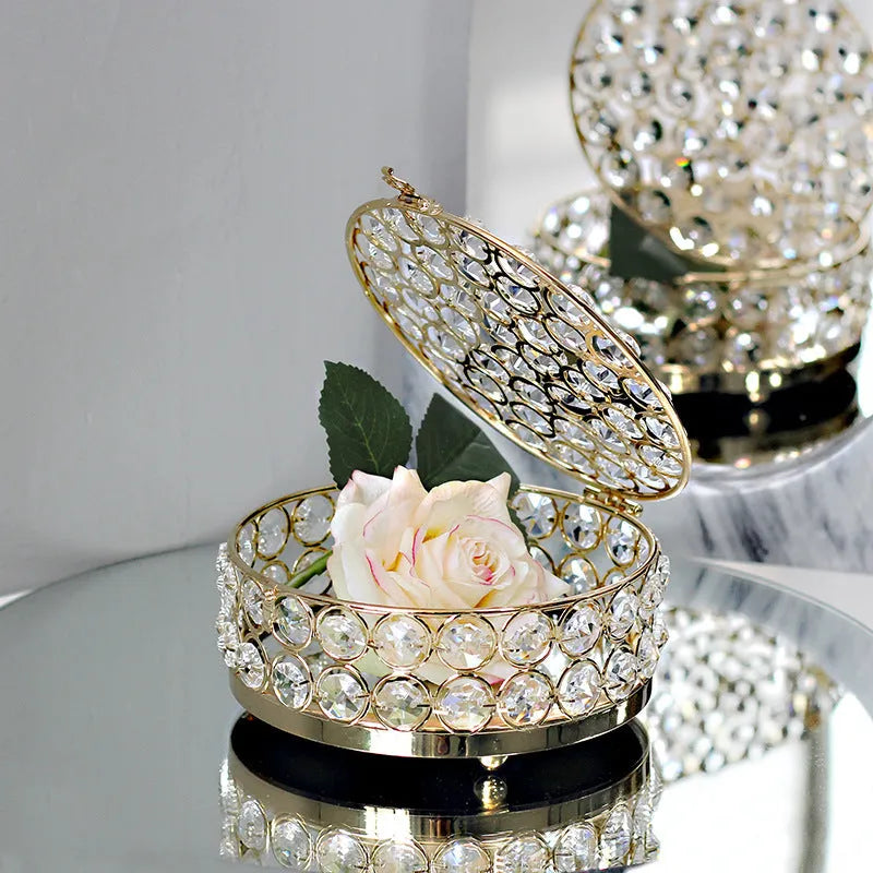 French gold metal jewelry box with a clear crystal glass lid and a lock, shown on a surface.
