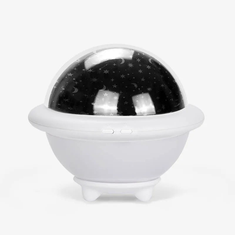 Green UFO shaped starry sky projection night light on a surface showing star projection.