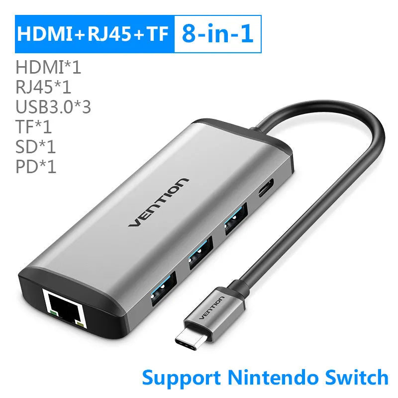 Deep grey USB-C to HDMI hub with Ethernet, USB ports, and memory card slots on a desk.