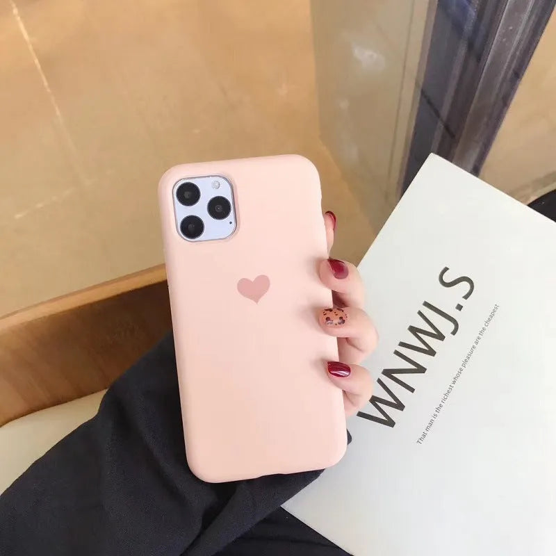Solid colour silicone phone case for iPhone, shown in dark green, on a table next to an iPhone.
