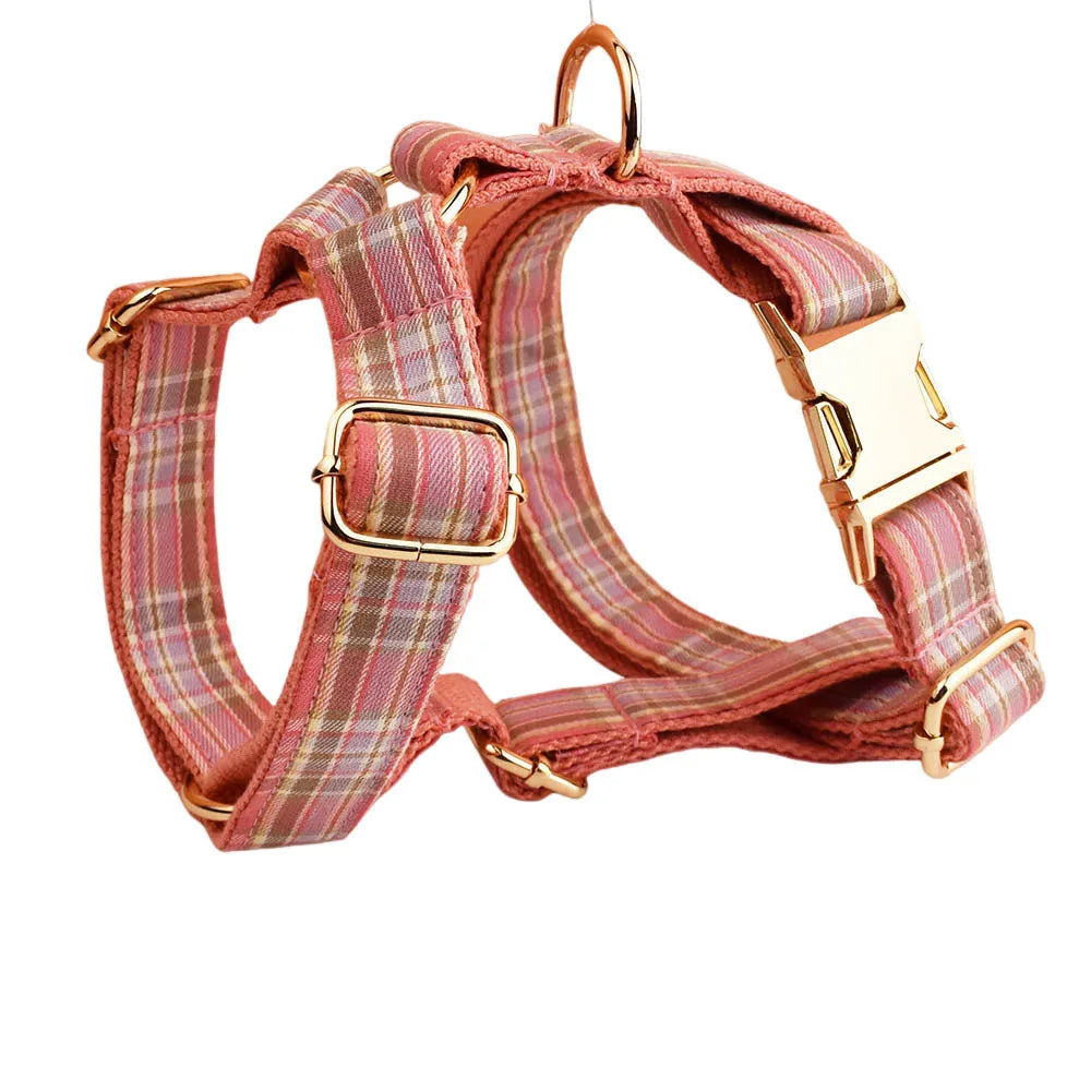 Plaid fabric dog collar, leash, bow, and vest four-piece accessory set on a white background.
