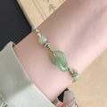 Women's copper bracelet with jade peace buckle and ethnic woven double-ring strap.