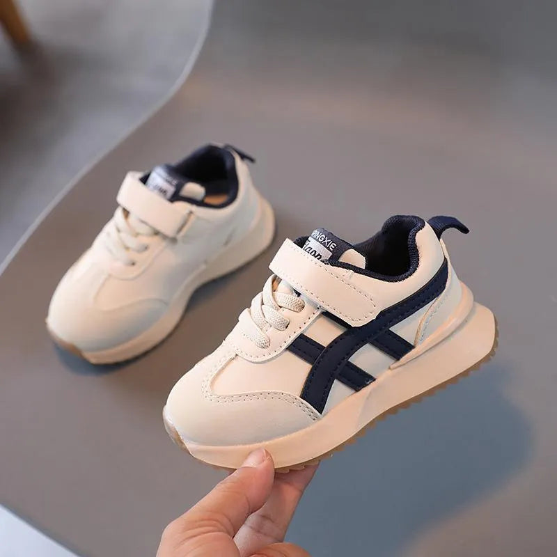 Children's white casual sneaker with Velcro strap and rubber sole on a neutral background.