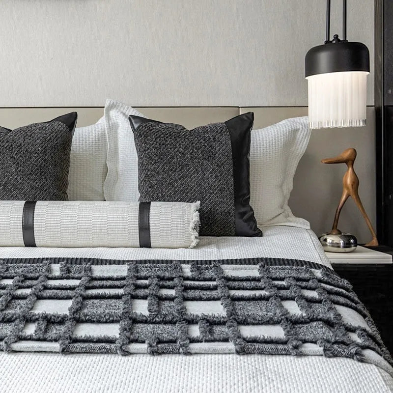 Modern grey and white plaid bed runner nap blanket set with pillow on a bed.