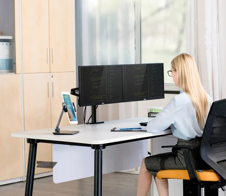 Silver foldable aluminium phone tablet stand with 360-degree rotating bracket on a desktop.