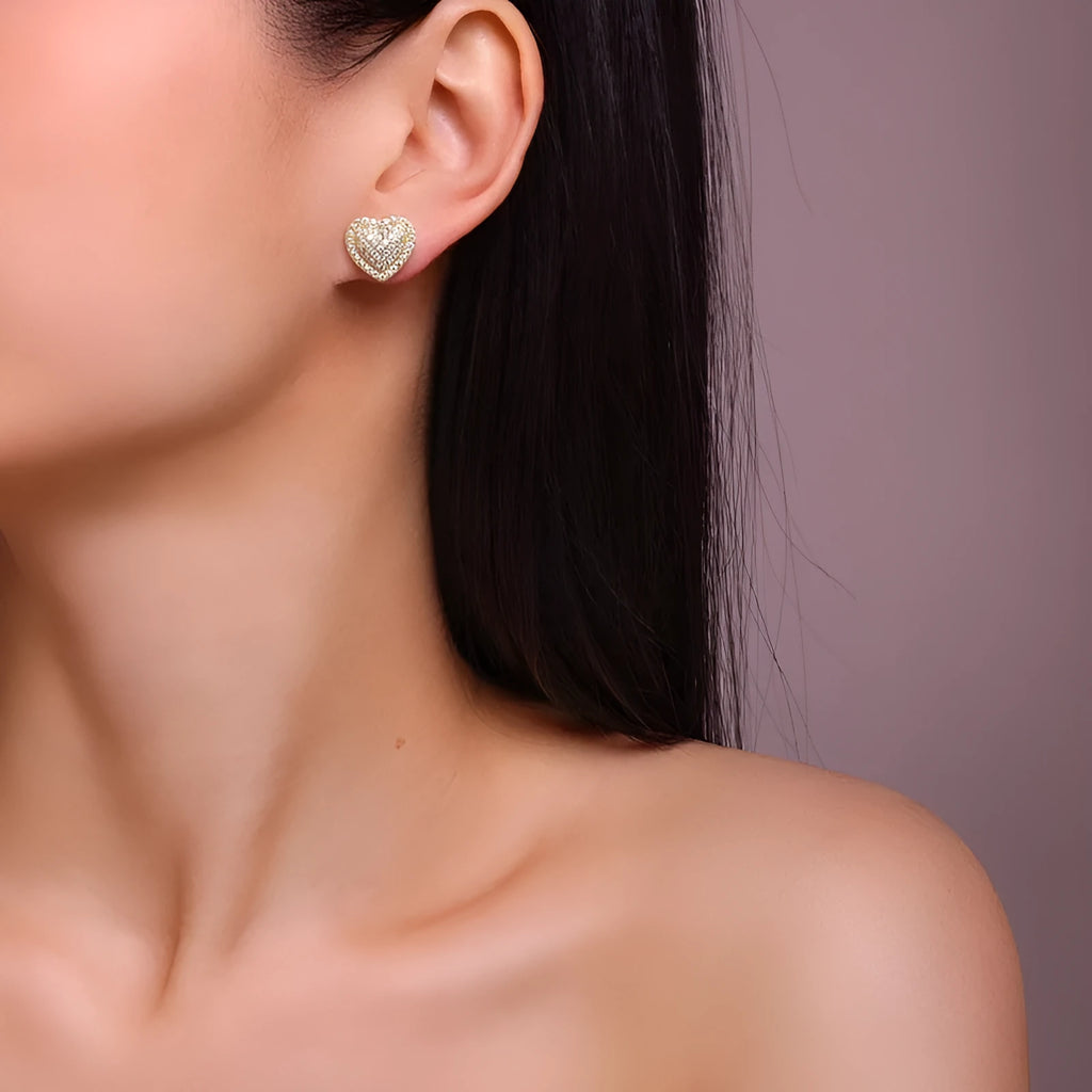 A pair of golden heart-shaped moissanite stud earrings on an S925 silver post.