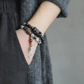Ethnic style black hair crystal bracelet with white crystal tassel decoration showing bending and lacing construction