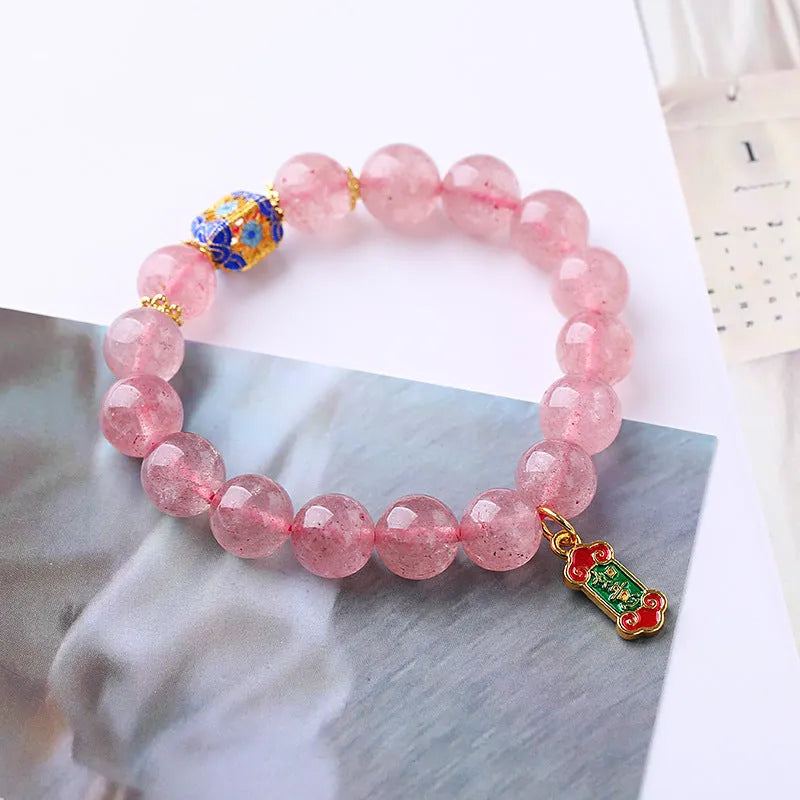 Close-up of hand-woven pink strawberry quartz crystal bracelet with Ruyi motif design