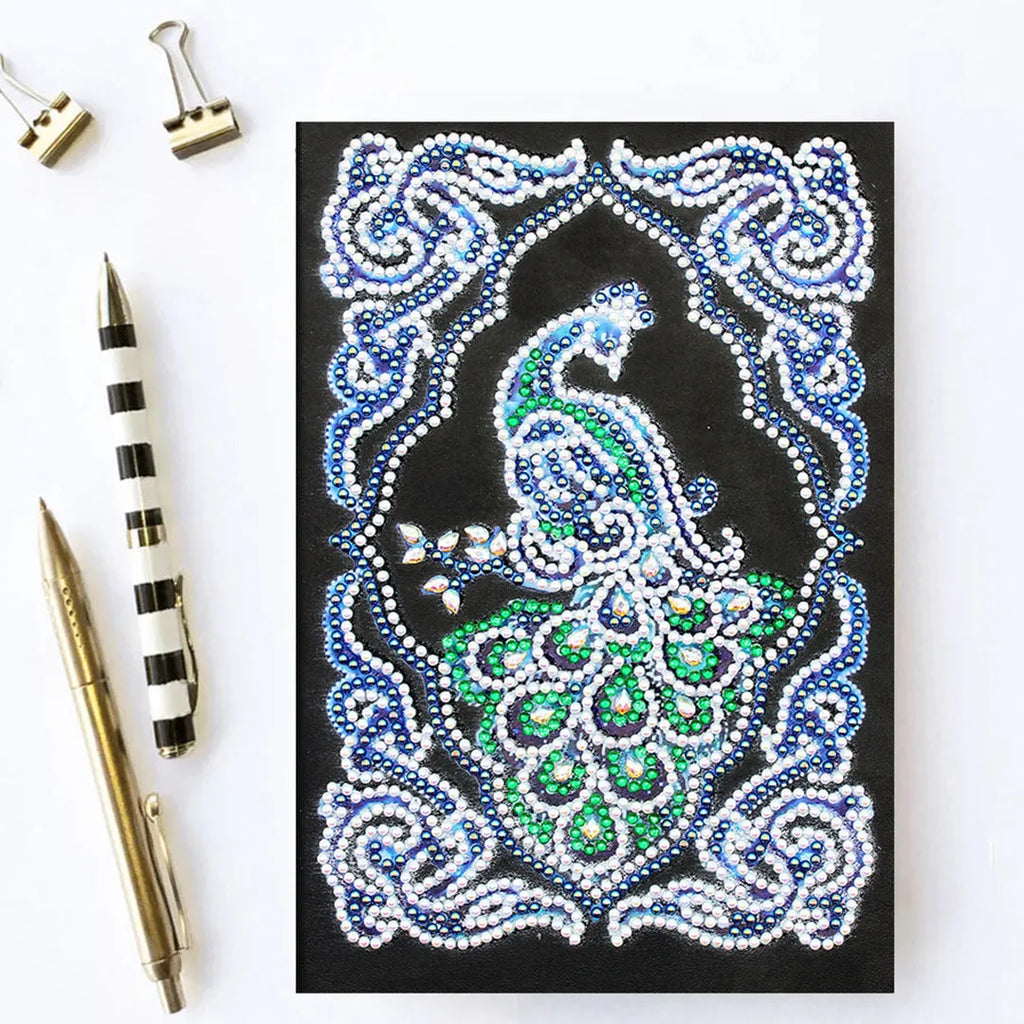 A5 diamond painting notebook kit with peacock design, shaped drills, and bright drills on black cover.