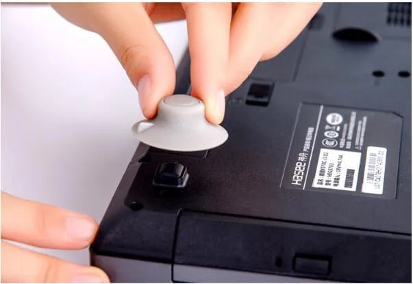 Grey plastic laptop cooling pad set showing two large and two small non-slip pads on a desk.