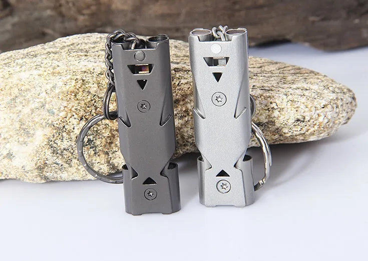 Compact keychain whistle in black and silver with keychain attachment for portable emergency signalling