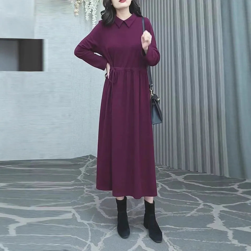 A purplish red long sleeve plus size dress for women, shown with extra-long sleeves and a long skirt.