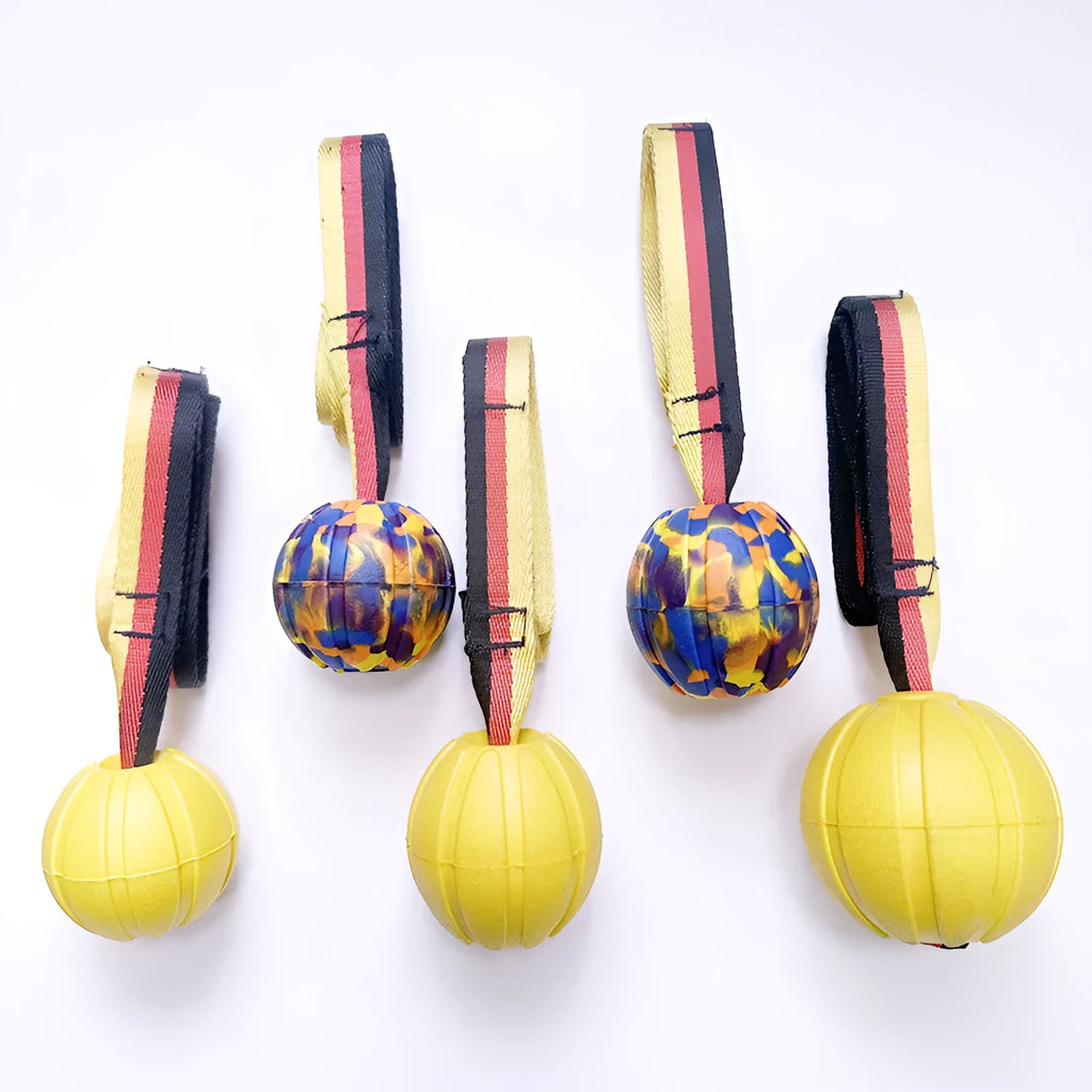 Yellow and camouflage coloured EVA floating dog balls with strings in three different sizes on a blue background.