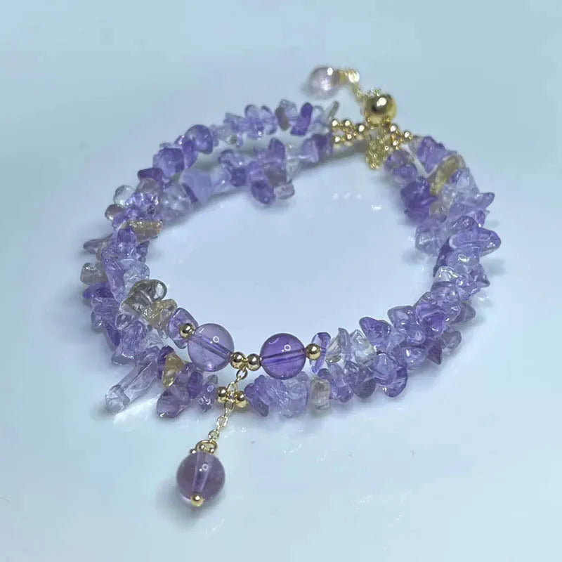 Close-up of a women's double row bracelet made from natural purple and golden D178 ametrine crystals on a wrist.