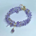 Close-up of a women's double row bracelet made from natural purple and golden D178 ametrine crystals on a wrist.