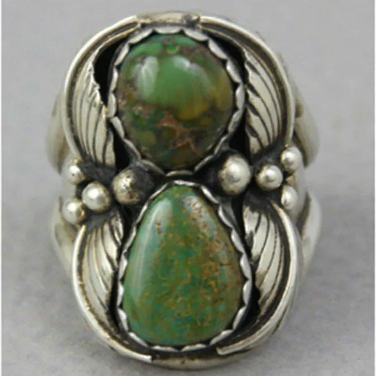 Women's geometric alloy ring with a turquoise coloured inlay, shown on a model's finger.