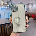 Purple silicone iPhone case with a 3D floral design and built-in spin stand on a table.
