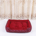 Round grey and white striped bolster dog bed on a wooden floor