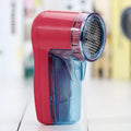 Portable electric clothes lint remover and pill shaver unit with compact white body.