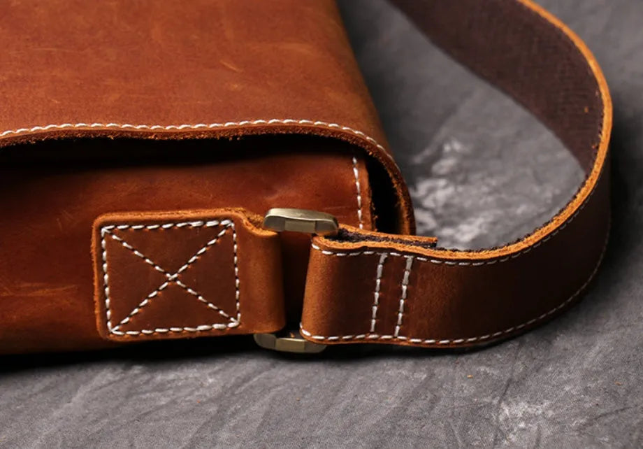 Vintage brown leather men's messenger bag with flap opening and adjustable shoulder strap.