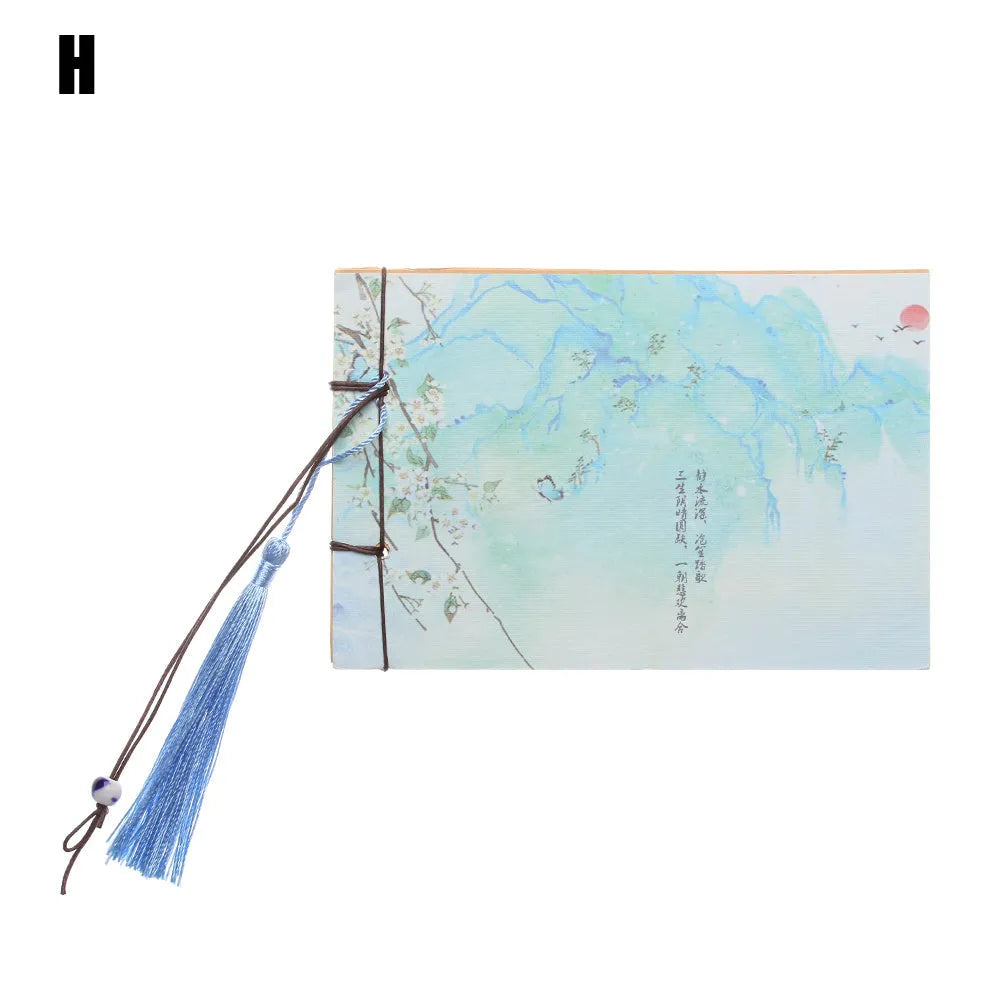 Kraft paper notebook with tassel bookmark showing hand-stitched binding and blank interior pages