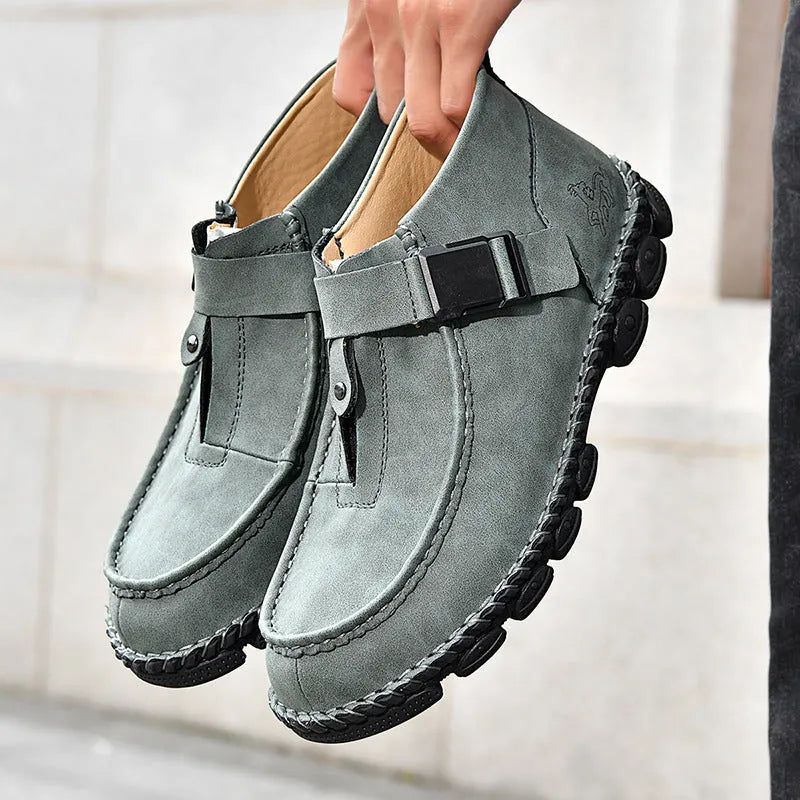 Handmade men's black synthetic leather slip on shoes with a flat heel on a plain background.
