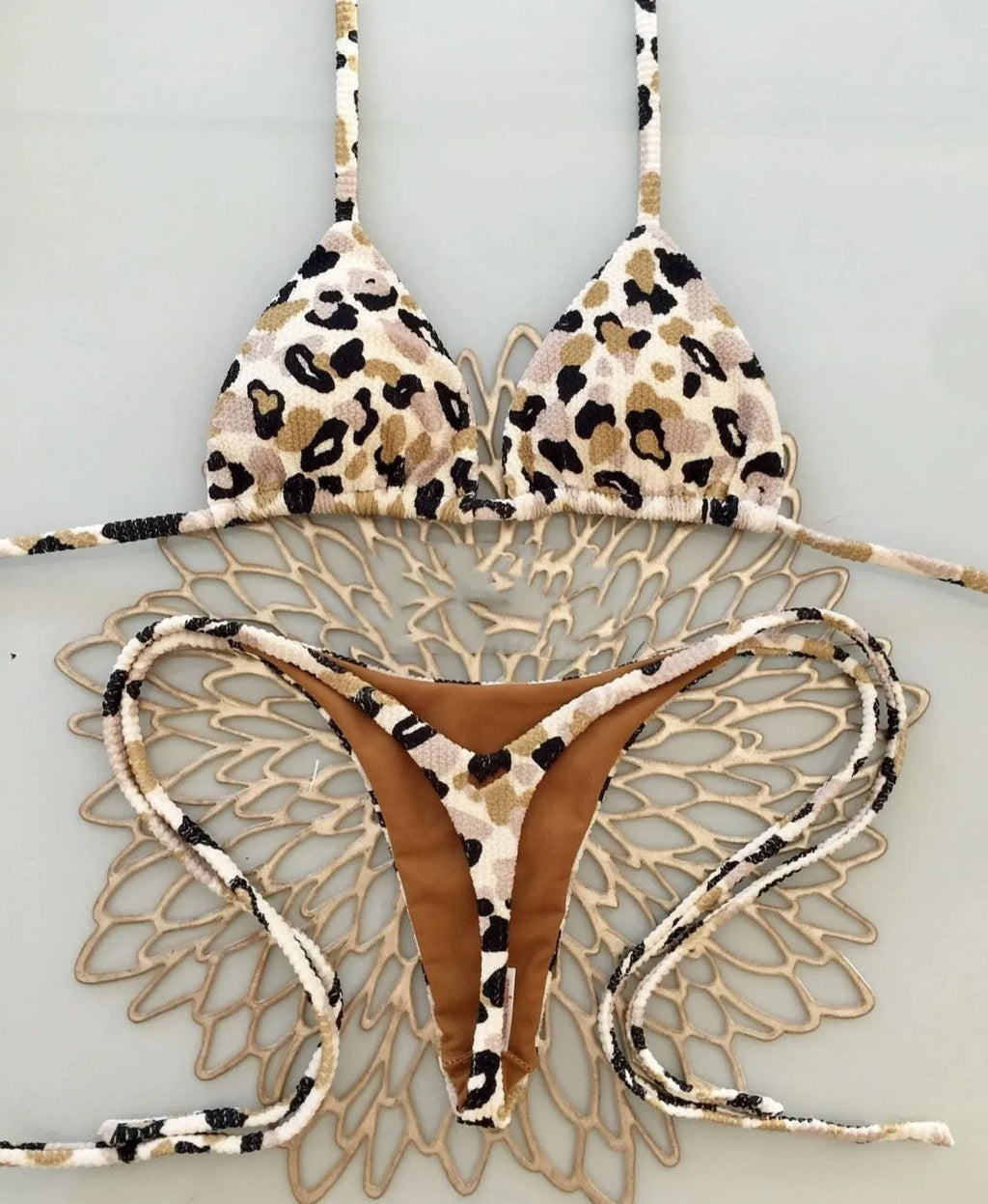 Women's printed bikini swimsuit on a hanger, showing briefs style and cotton lining detail.