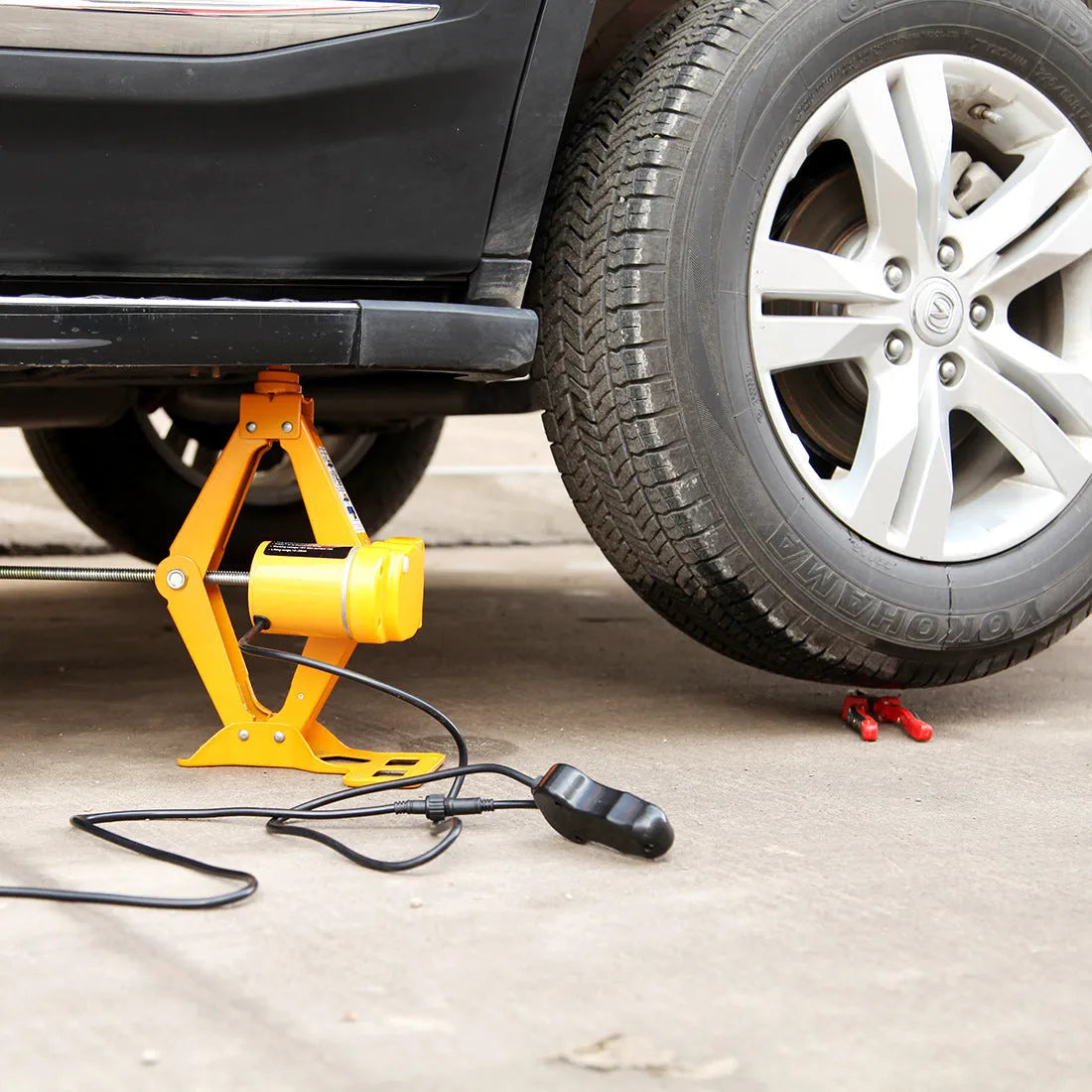 Electric hydraulic car jack with control unit showing 2-ton capacity and height adjustment