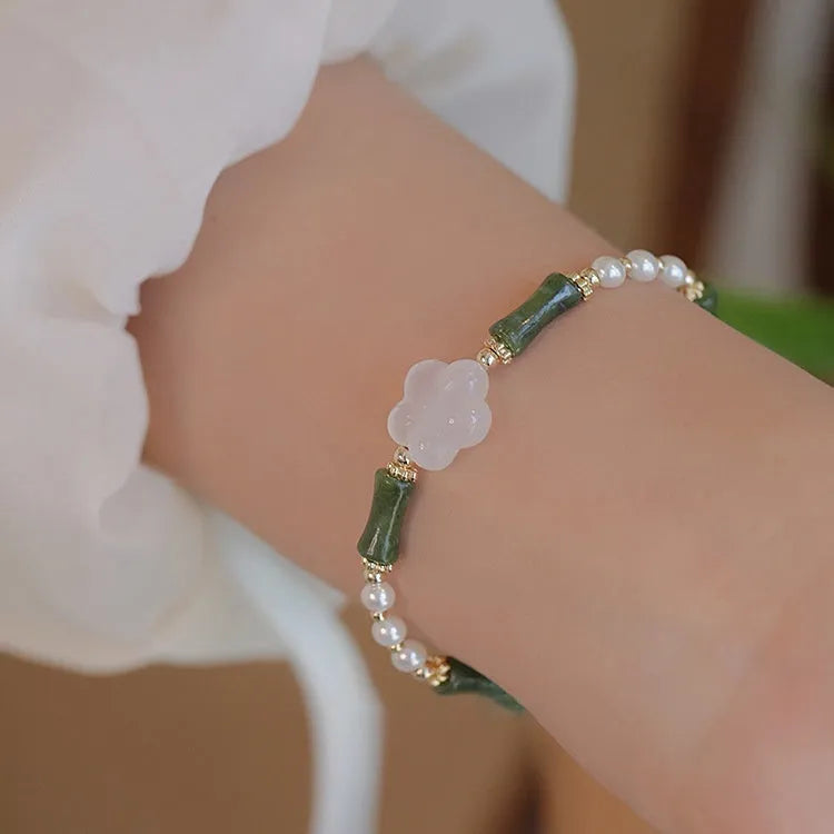 Handmade antique style bracelet with Hetian jade, copper shell pearls, and bamboo joint detail.
