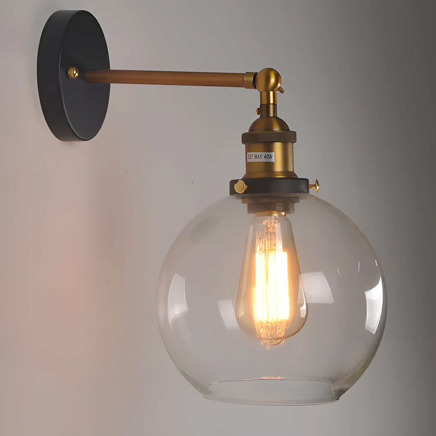 Close-up of a retro-style spherical glass wall lamp in amber, showing its aluminium holder and round shape.