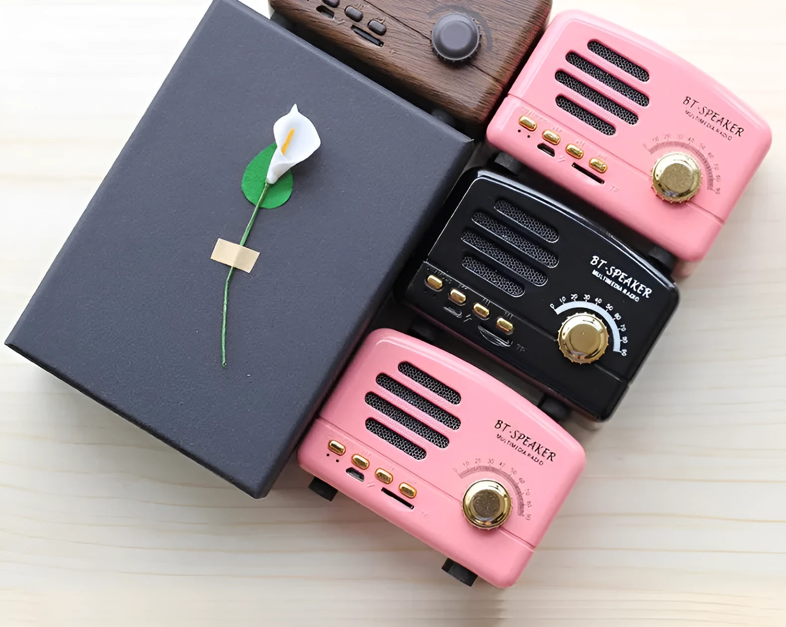 Compact Bluetooth speaker with wood grain finish, showing front grill and control buttons.