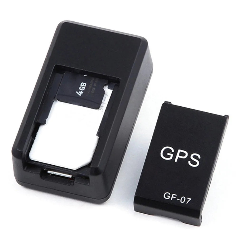Small black magnetic GPS tracker device next to a USB charging cable.