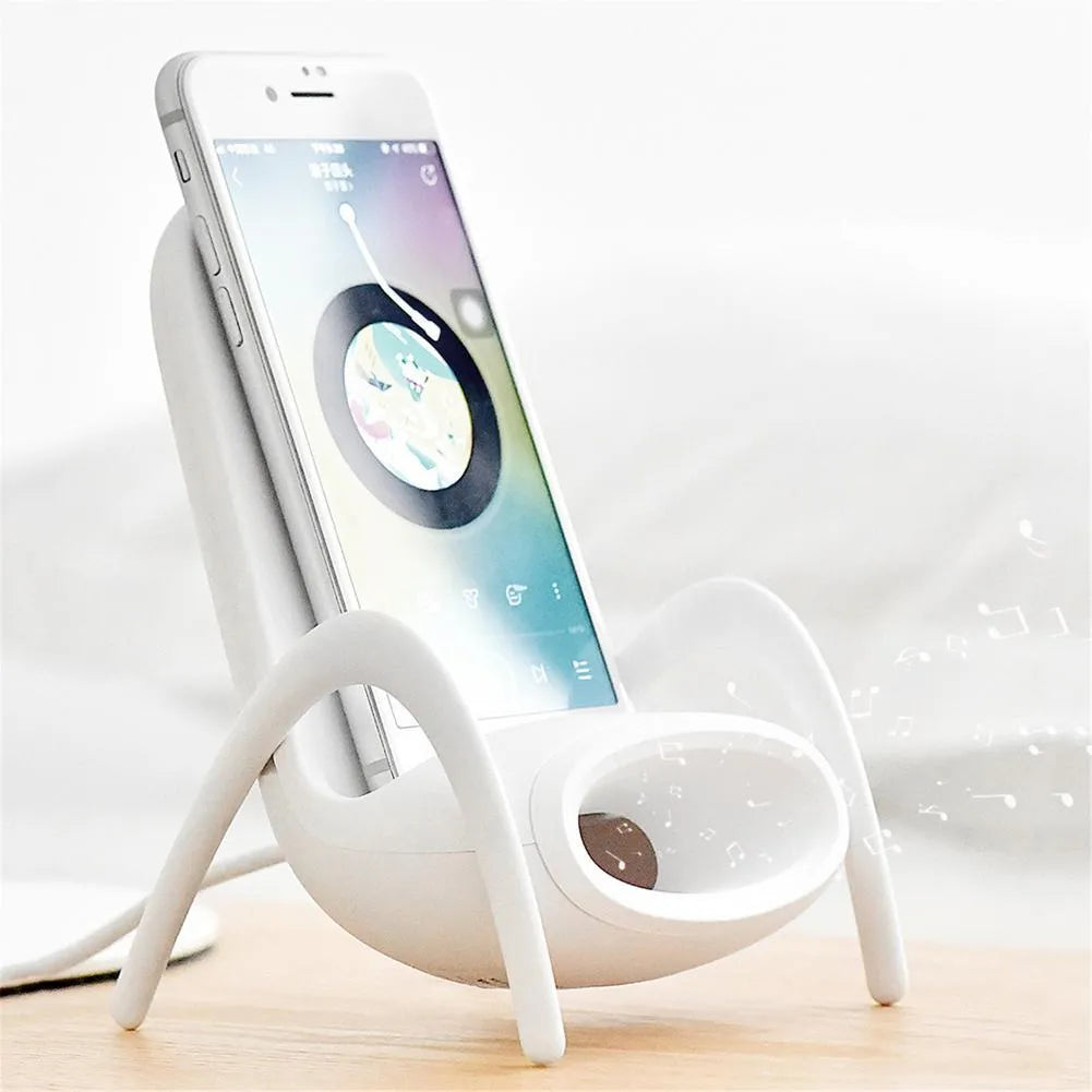 White mini chair shaped wireless charging stand holding a mobile phone at an angle